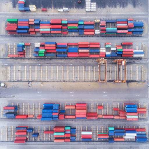 Luftbild von Containerterminal mit bunten Frachtcontainern und Kränen